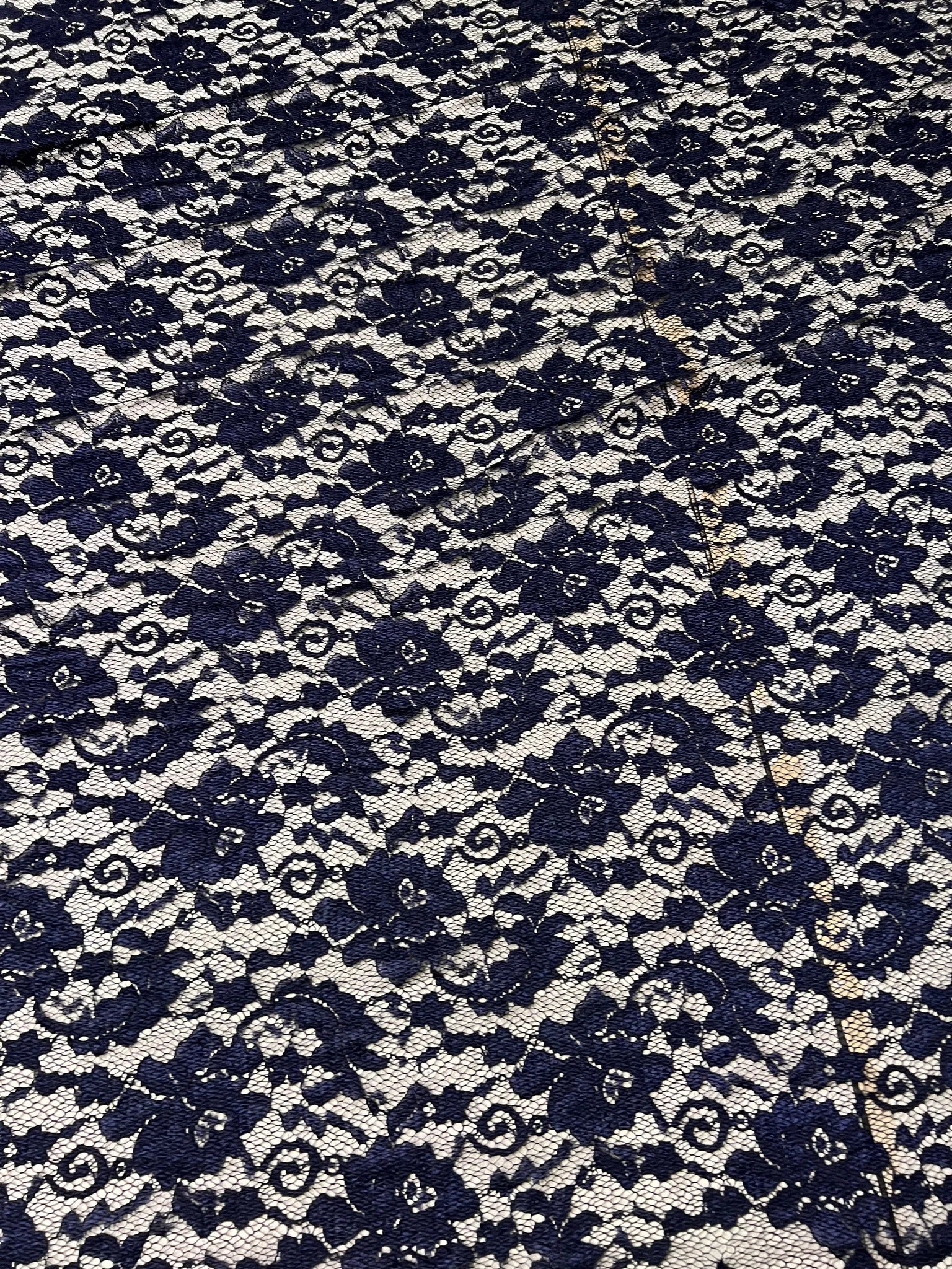 Elegant navy lace fabric draped for sewing projects