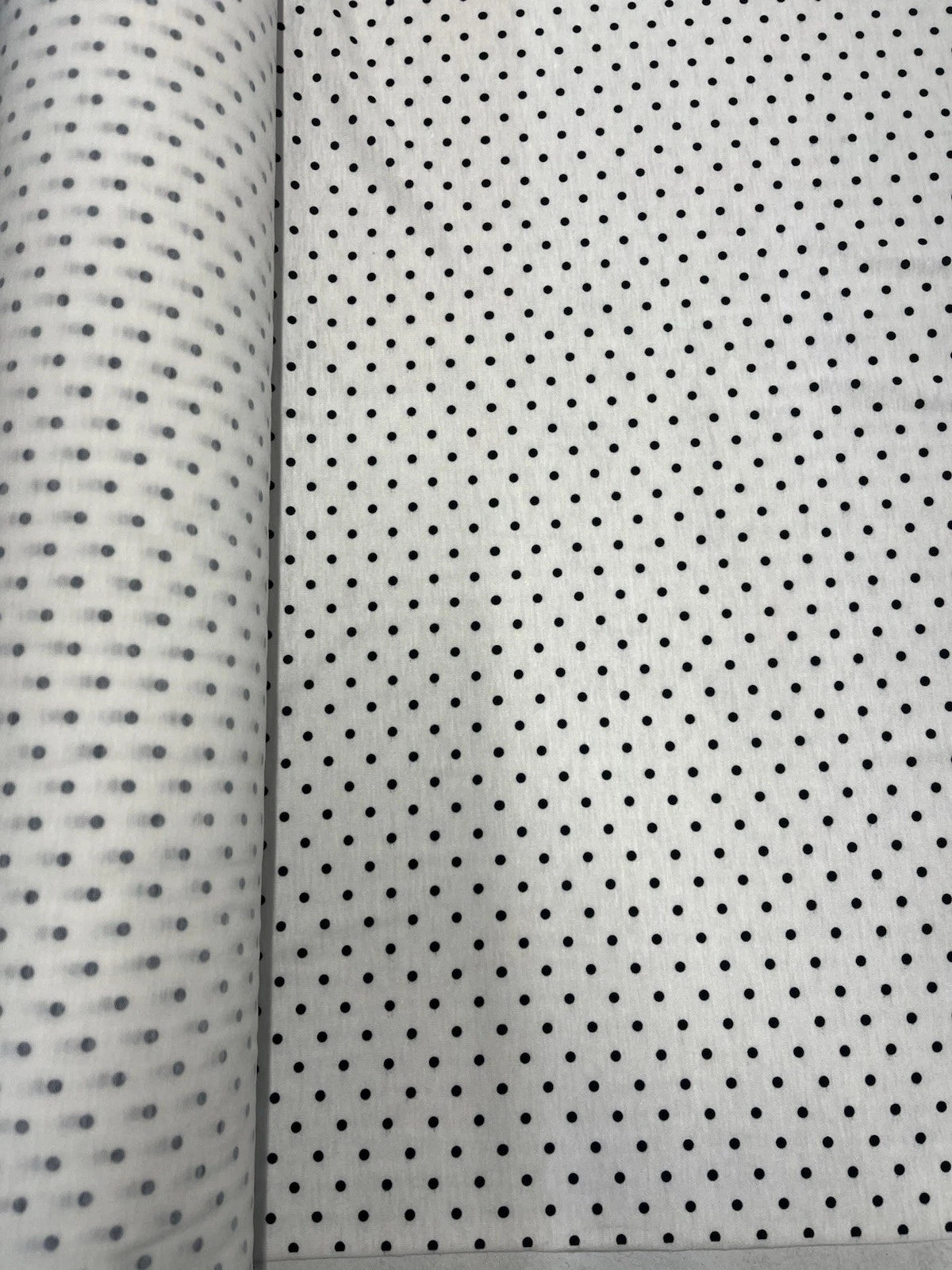 Two swatches of fabric with black dot patterns on a white background