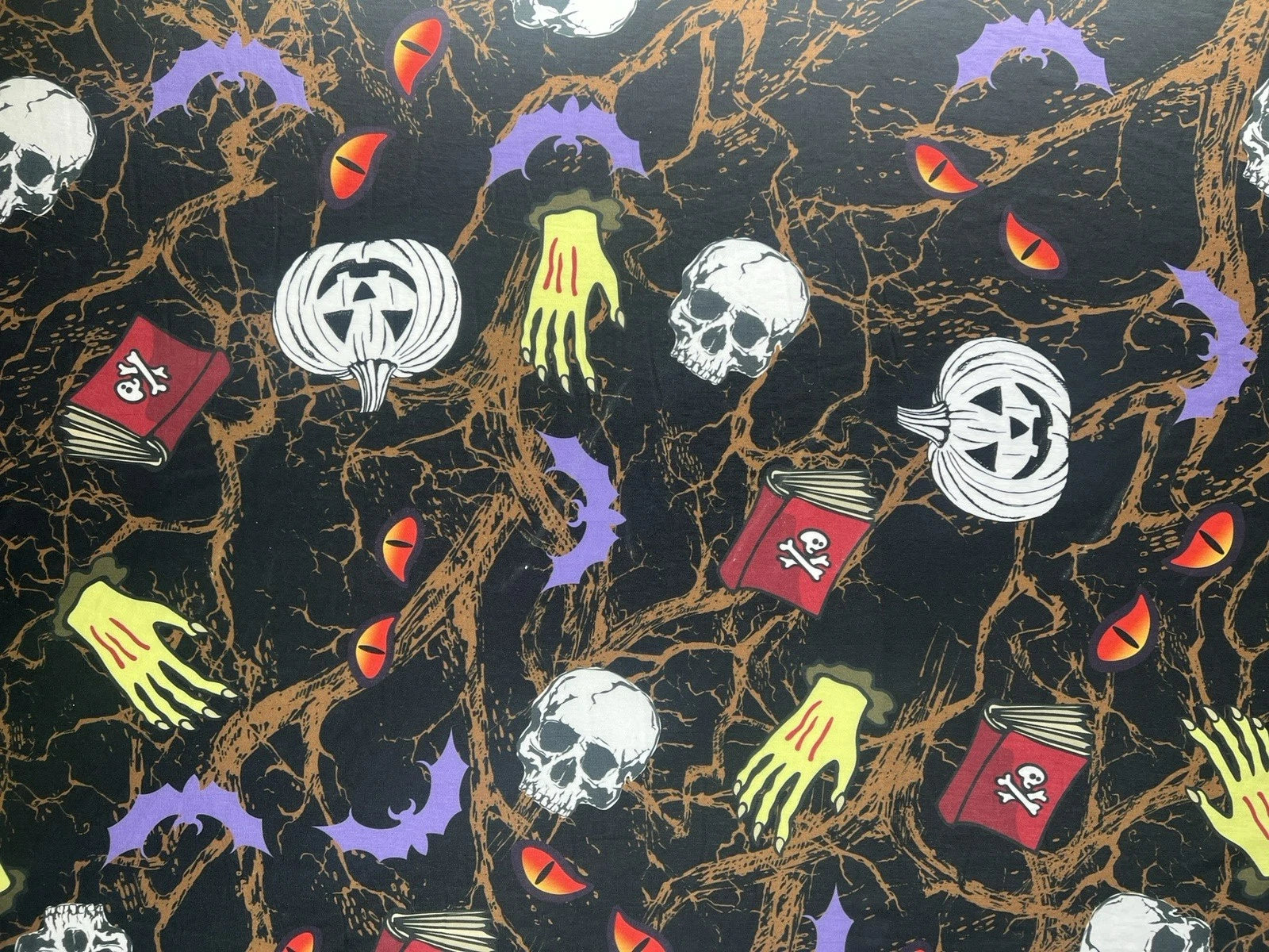 Halloween-themed pattern with pumpkins, skulls, and books on a black background.
